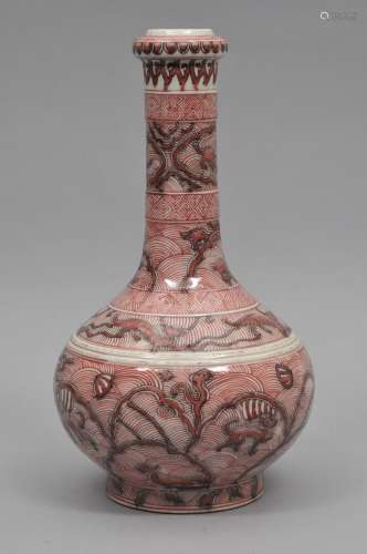 Porcelain vase. China. 19th century. Bottle form with a garlic mouth. Underglaze red decoration of stylized mythical animals on a wave ground. K'ang Hsi mark. 12-1/4