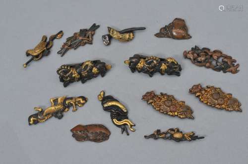Lot of assorted sword mounts. Japan. 18th/19th century. Three sets of menuki (one pair mounted as pins and seven single menuki (mixed metal work).