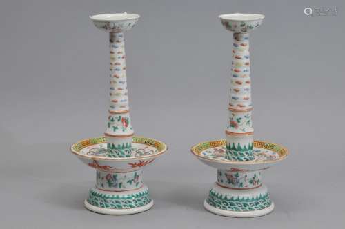 Pair of porcelain candle prickets. China. 19th century. Famille Rose decoration of reserves with figures, insects, flowers and clouds. 13