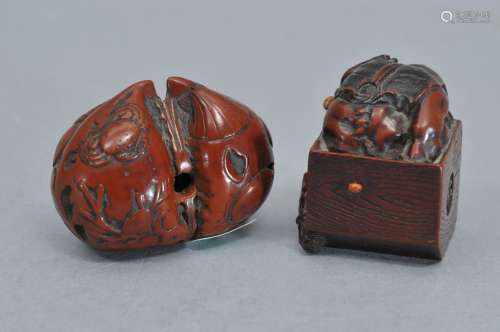 Lot of two Netsukes. Japan. 19th century. A contortionist inside a box signed Masatomoto carved in wood. A fruit pit carved with relief decoration of abalone shells. 1-1/4