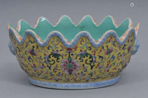 Porcelain bowl. China. 19th century. Oval form with ch'ien Lung mark. renalated edge, foo dog handles. Decoration of lotus scrolls on a yellow ground. Ch'ien Lung mark. 8