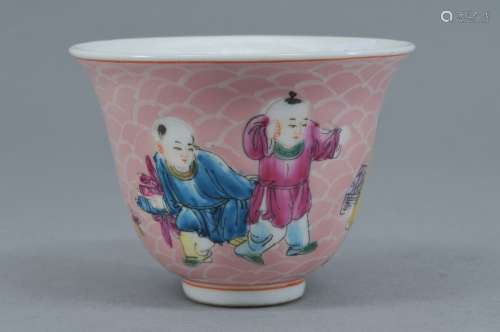 Porcelain wine cup. China. Early 20th century. Famille Rose decoration of children on a pink wave ground. 2-3/4