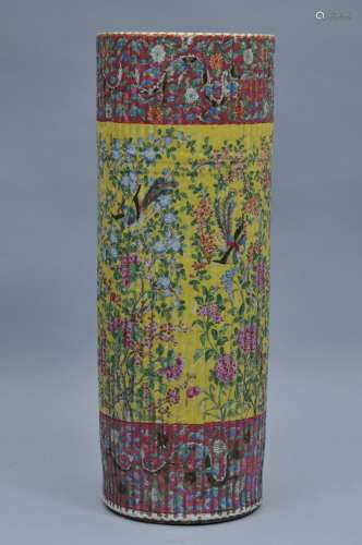 Porcelain umbrella stand. China. 19th century. Cylindrical form with a ribbed body. Burgundy coloured top and base decorated with flowers. Yellow central section with birds and flowers. Crack. 24-1/2