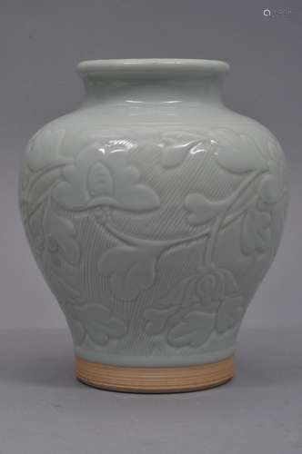 Porcelain vase. China. Early 20th century. Carved decoration of floral scrolling. Pale celadon glaze. Drilled. 7