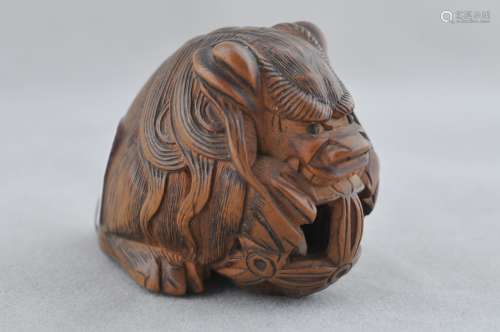 Carved wood Netsuke. Japan. 19th century. Shishi with a