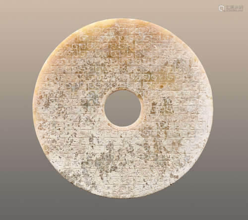 AN INTERESTING PARTLY CALCIFIED BI DISC WITH A GLASSY POLISH AND AN INCISED PATTERN OF LINKED SCROLLS