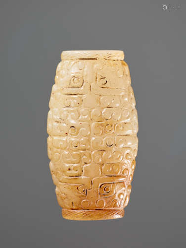 A SUPERB BARREL-SHAPED BEAD IN WHITE JADE WITH MASK MOTIFS AND CURLS IN RELIEF