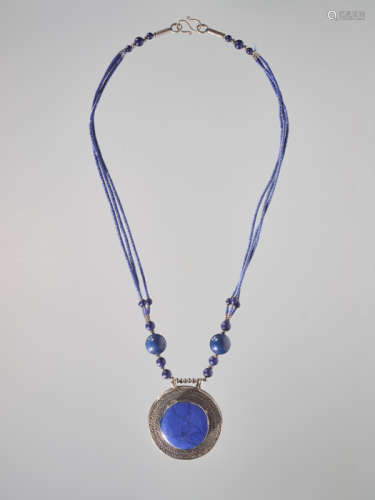 A SINO-TIBETAN SILVER AND LAPIS AMULET ON A NECKLACE, 20th CENTURY