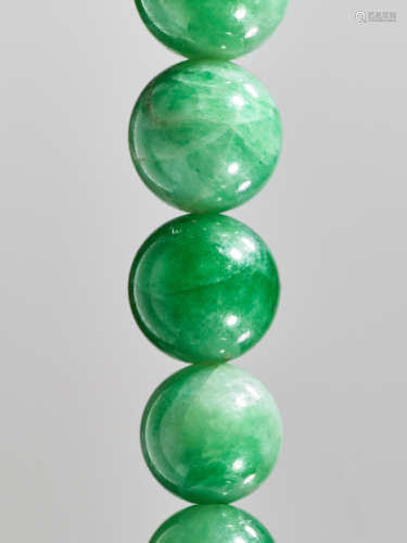 AN EMERALD GREEN JADEITE NECKLACE, 88 BEADS, WITH ORIGINAL SILVER CLASP, QING DYNASTY