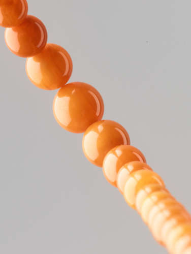 AN ‘EGG YOLK’ BALTIC AMBER NECKLACE, 52 BEADS, QING DYNASTY