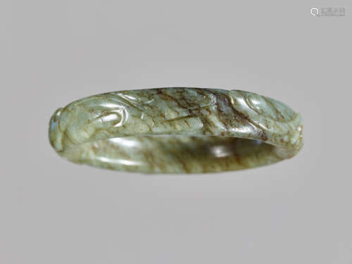 A CELADON AND RUSSET JADE ‘CHILONG’ BANGLE