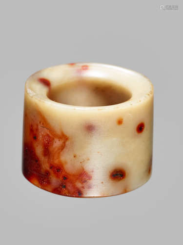 A WHITE AND IRON RED JADE ARCHERS RING, LATE MING DYNASTY