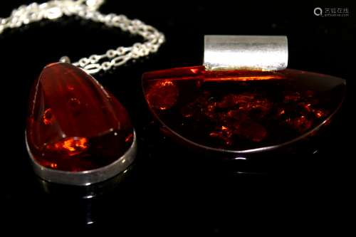 Two Amber and sterling silver pendants.