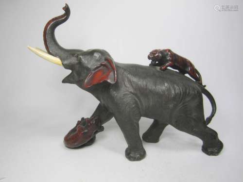 A METAL ELEPHANT WITH ATTACKING LIONS