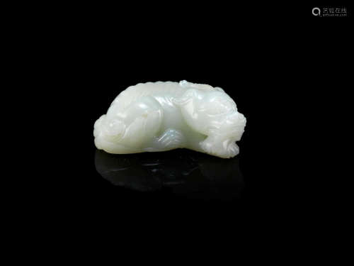 A WHITE JADE CARVING OF A HORNED MYTHICAL BEAST