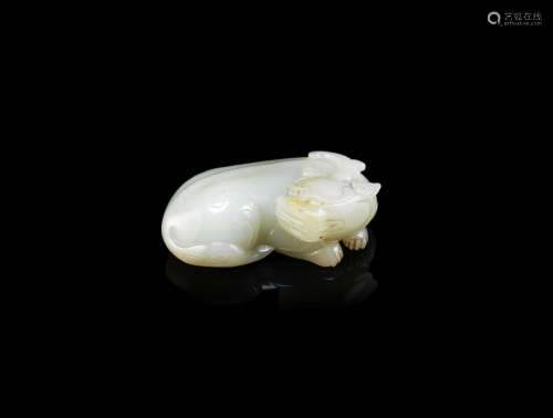 A PALE GREEN JADE ARCHAISTIC CARVING OF A MYTHICAL BEAST