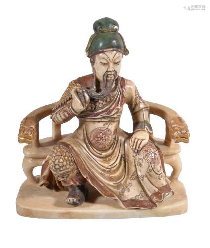 A Chinese soapstone figure of Guan Yu, seated on a seat with dragon handles