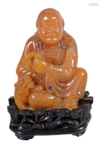 A Chinese caramel coloured Shoushan soapstone Lohan, of Tianhuang-type