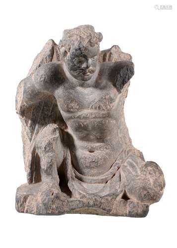 A Gandhara grey schist architectural relief fragment depicting Atlas