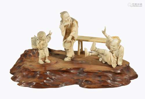 Ω A Japanese ivory Okimono of three carved ivory figures