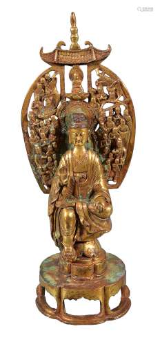 A gilt-bronze figure of Guanyin, seated on a open lobed hexagonal base