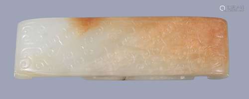 A Chinese white and russet jade sword slide, carved with formal archaic motifs