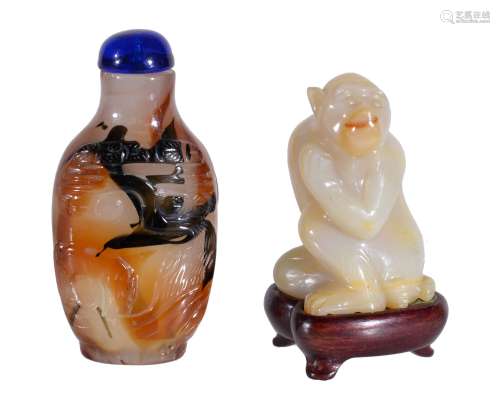 A Chinese agate snuff bottle, the carved surface with brown an black inclusions