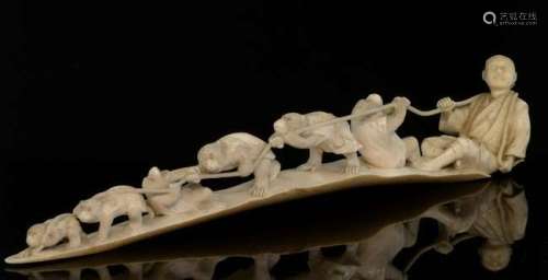 Late 19th/early 20th century Japanese carved ivory group of six monkeys playing tug-of-war with a man sitting on the ground, inset red signature cartouche to base, 37cm long,PLEASE NOTE: THIS ITEM CONTAINS OR IS MADE OF IVORY. Buyers must be aware t