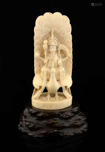 Late 19th century Japanese ivory carved as a four armed figure sitting on a lotus flower on top of a peacock, inset red cartouche to base, 20cm high, with a non-matching hardwood base,PLEASE NOTE: THIS ITEM CONTAINS OR IS MADE OF IVORY. Buyers must