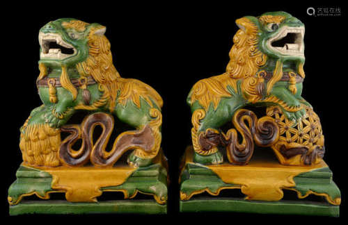 Pair of Chinese pottery dogs of fo in yellow, green and brown glazes, on integral stands, 38cm high,