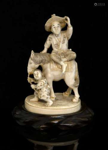 Late 19th/early 20th century Japanese carved ivory okimono of a man on a horse being led by a young boy, inset red signature cartouche to base, 12cm high, on hardwood base,PLEASE NOTE: THIS ITEM CONTAINS OR IS MADE OF IVORY. Buyers must be aware tha