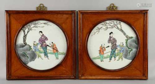 Pair of 20th century Chinese circular porcelain plaques depicting figures in a garden setting, 26cm diameter, in hardwood frames,