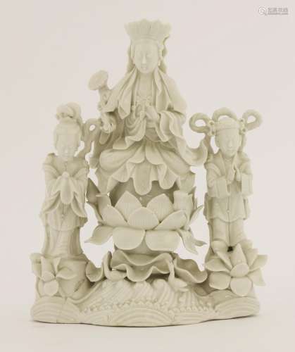 A Chinese blanc de Chine group, 19th century, the centre with Guanyin seated cross-legged on a ...