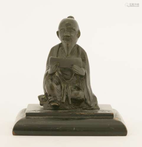 A Chinese bronze figure, probably 17th century, of a seated scholar reading a scroll, 9.5cm, fixed ...