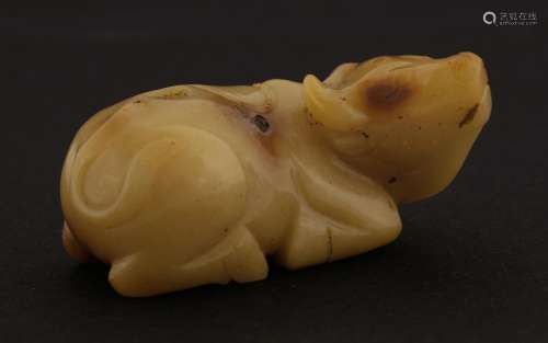 A Chinese jade buffalo,  recumbent with well engraved hair, tail and robe, the stone of a yellow ...