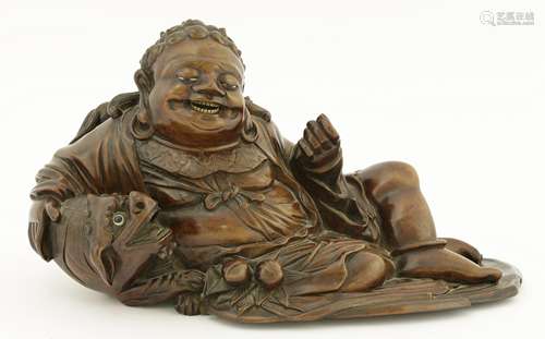 A Chinese wood figure, 19th century, of a bodhisattva lying to his side with Buddhist lion in his ...