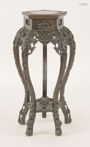 A Chinese rosewood vase stand, c.1900, of pentagonal form, carved and pierced with xi ...