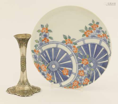 A Japanese nabeshima dish, 19th century, painted with two wheels surrounded by flowers, the ...