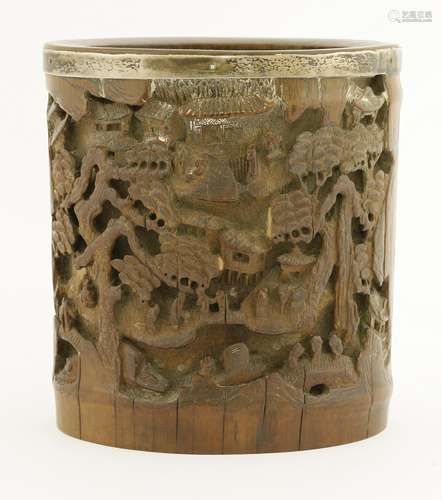 A Chinese bamboo brush pot, 19th century, carved with a village behind two big pine trees, figures ...