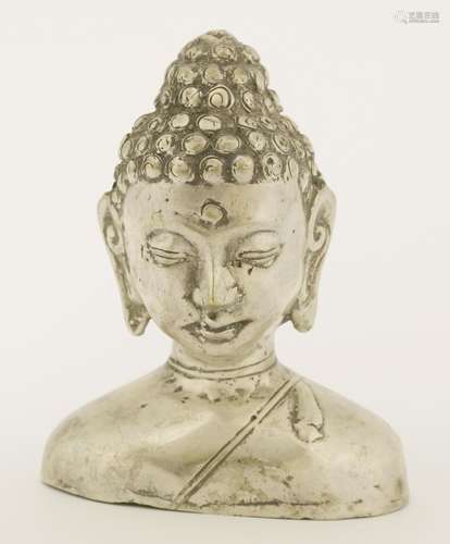 A metal head of Buddha's bust, 19th century, Burmese or Thai, his eyes looking down with a calm ...