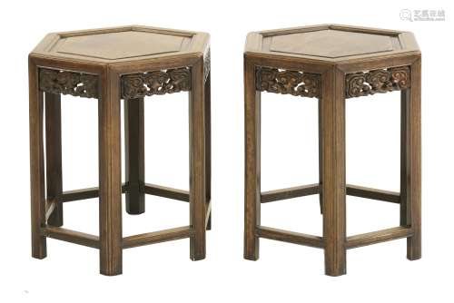 A pair of Chinese hardwood vase stands, 19th century, each with an hexagonal top above an apron ...