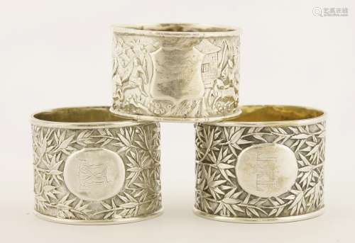 Three Chinese silver napkin rings, late 19th century, one with warriors on horses amongst woods and ...