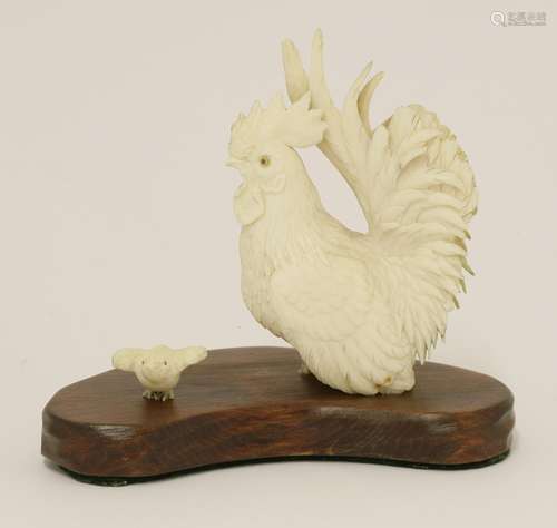 A Japanese ivory cockerel, Meiji period (1868-1912), his feathers carved in details, together with ...