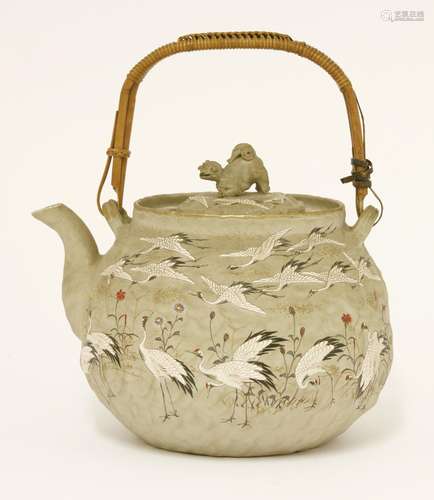 A Japanese stoneware teapot, late 19th century, with numerous cranes and flowers, Buddhist lion ...