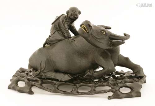 A Chinese wood carving, possibly early 20th century, with a boy riding on the back of a buffalo, ...