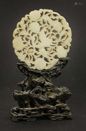 A Chinese jade plaque, late Qing dynasty, pierced and carved with a crane amongst fruiting vines,  ...