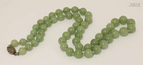 A jade bead necklace, 20th century, with silver clasp, 30cm