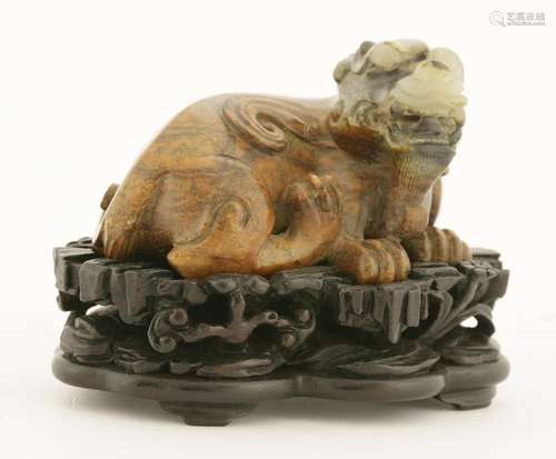 A Chinese hardstone carving, of a recumbent mythical beast with his head tilted to the right, ...