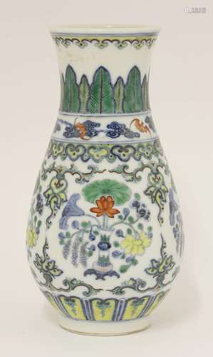 A Chinese doucai vase, painted with vases of lotus, millet and peony between ruyi head and false ...