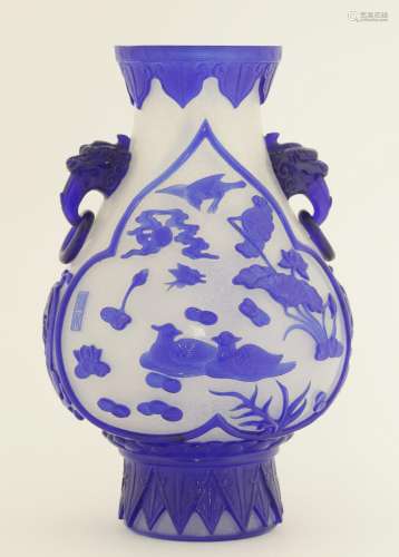 A Chinese overlay Peking glass vase, decorated in blue against a snowflake ground, with mandarin ...